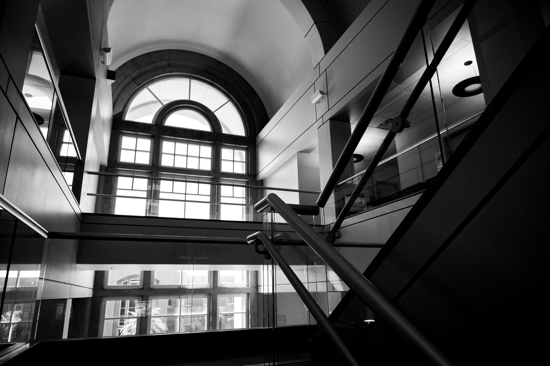 View of a large window from the staircase of a hallway